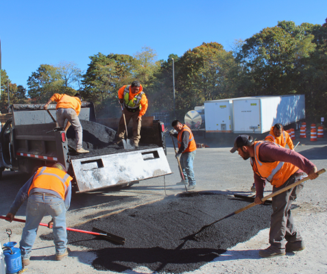 Center Maintenance crew spreading hot-mix asphalt to repair a commercial parking lot on Long Island